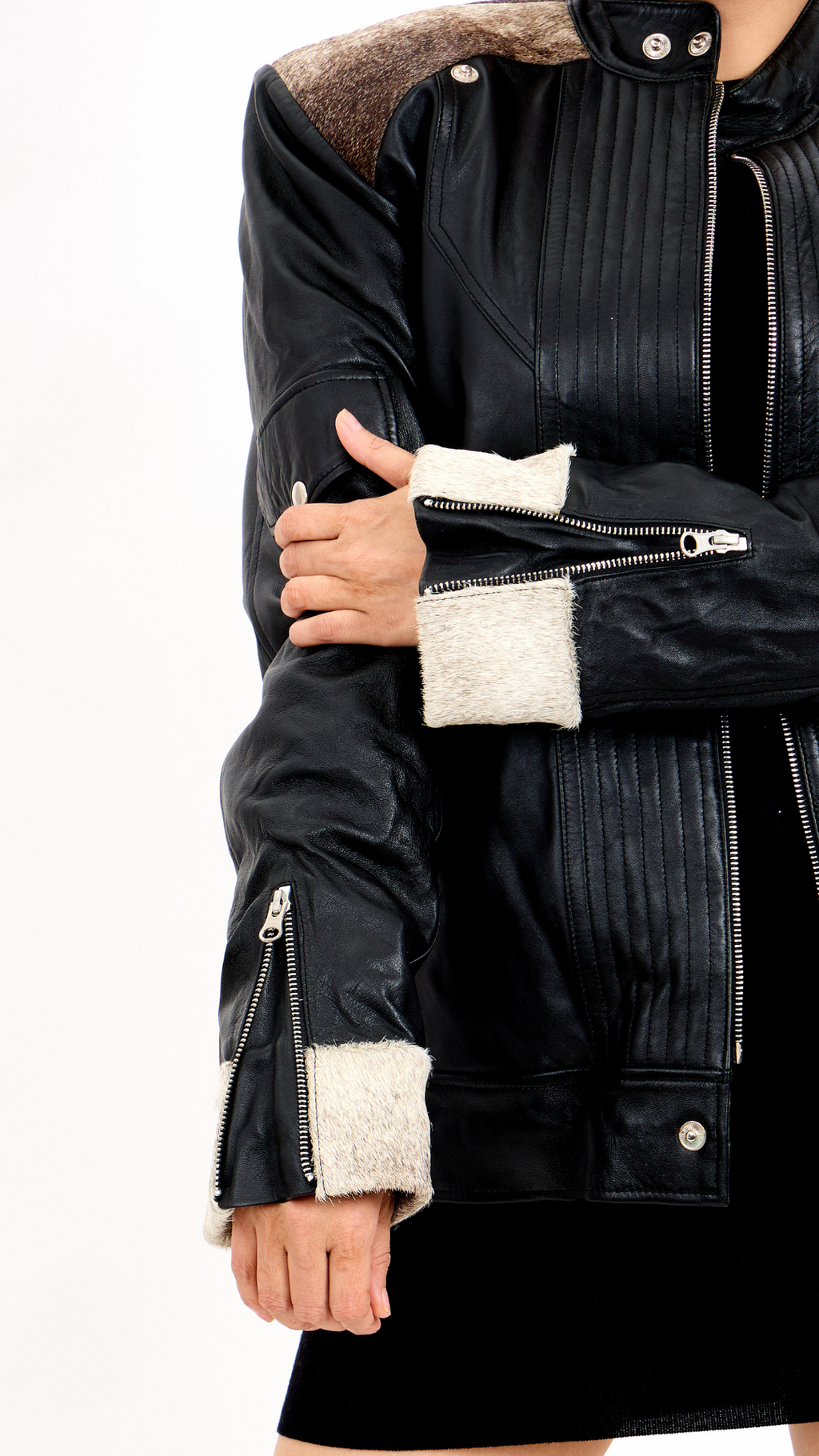 Black leather jacket with white cuffs and lining on a white background